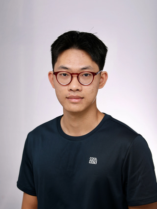 Man with dark blue shirt, wearing brown glasses.
